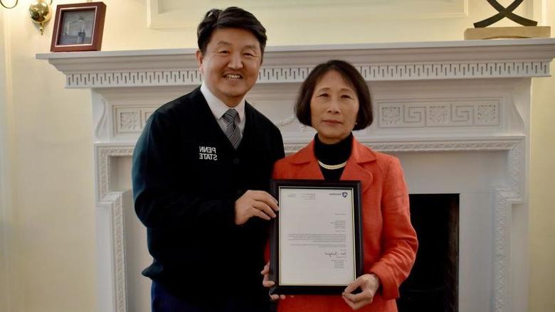 365英国上市校长兼首席学术官Jungwoo Ryoo, 正确的, 向冯娟·沃纳赠送了一份装裱好的证明她为杰出教授的信件副本, 这所大学最高的教授荣誉